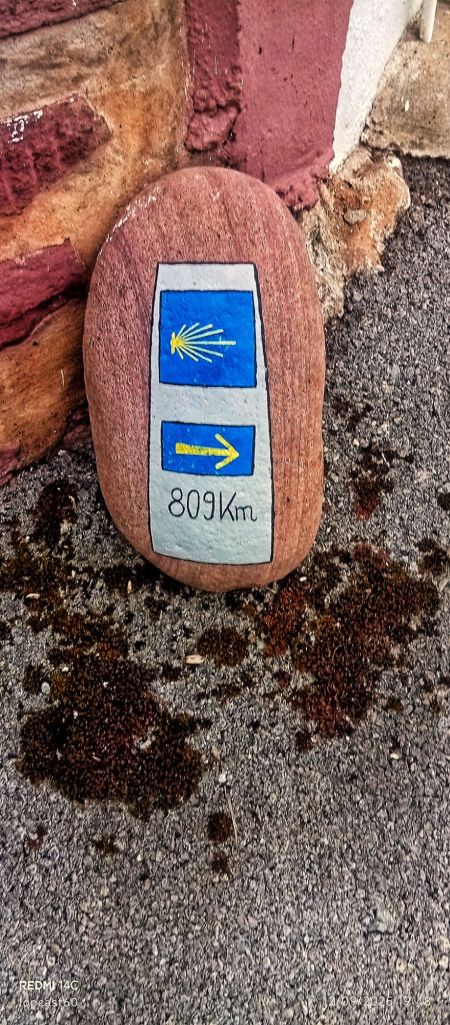 Jolie petite borne paint a la main, nous avertissant du temps pour arriver à Saint Jacques de Compostelle.